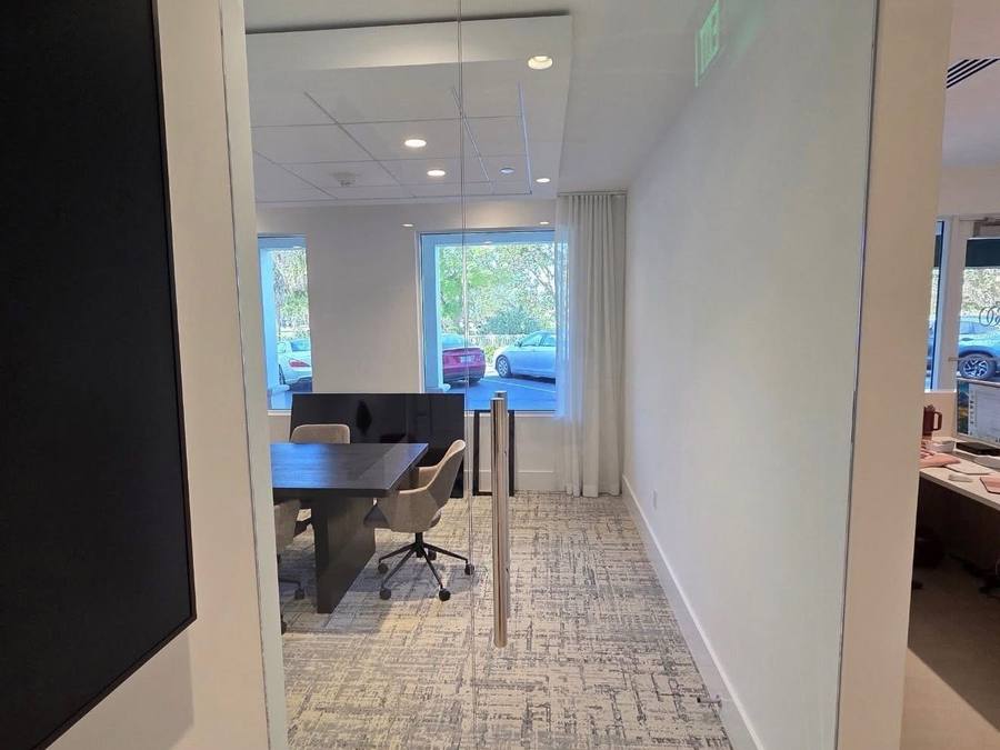 Frameless glass office partition with polished stainless framing