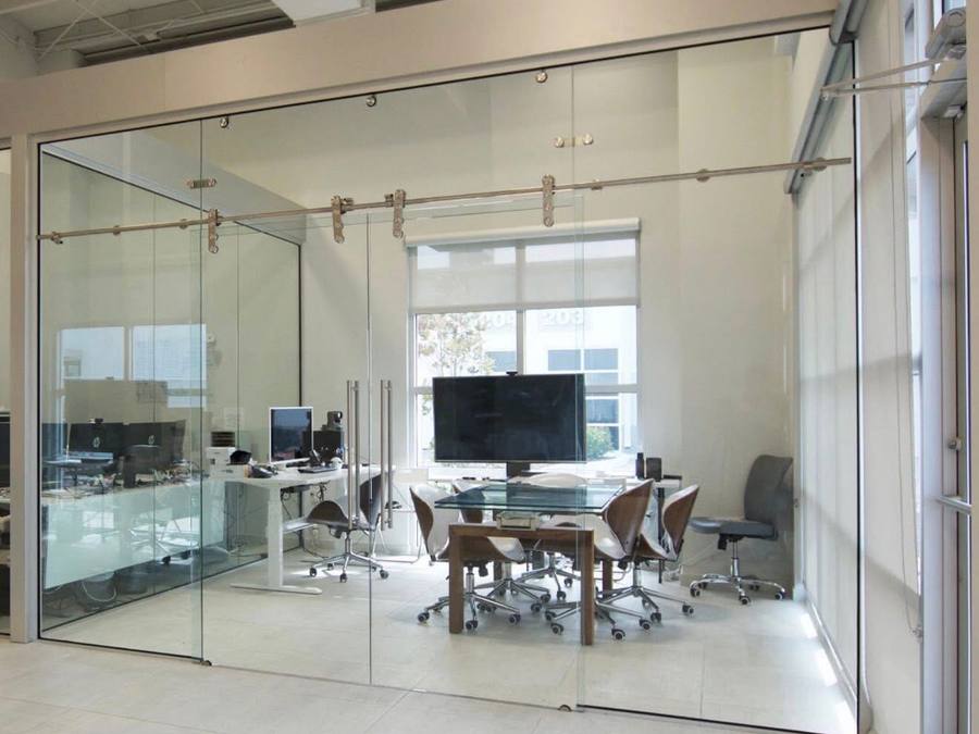 Glass-walled meeting room with sliding barn-style glass doors